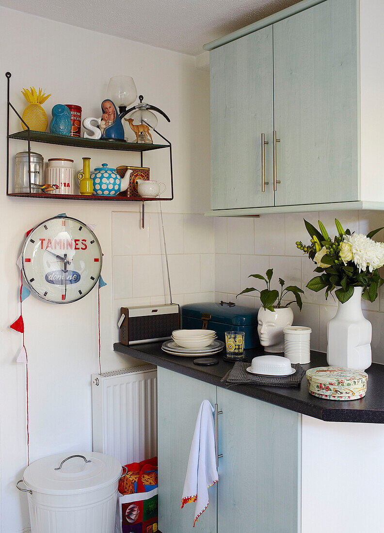 Küchenutensilien und Uhr mit Einbauschränken in der Küche eines Familienhauses in Margate Kent England UK