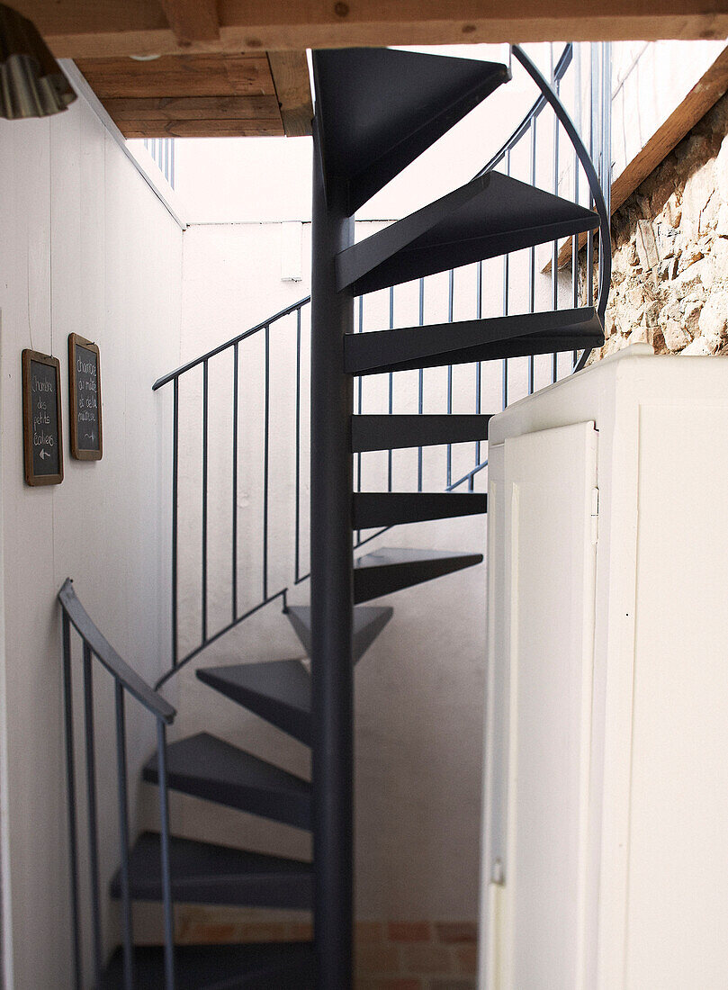 Black metal spiral staircase in schoolhouse conversion Brittany France