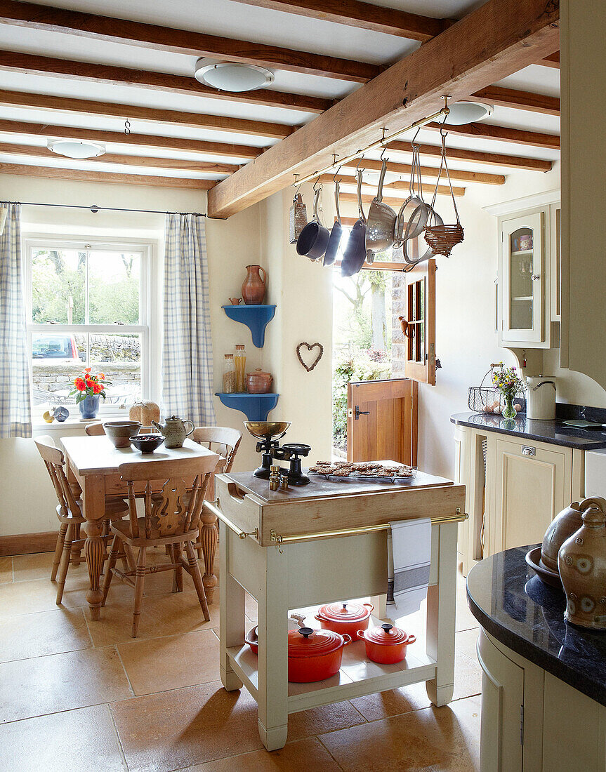 Beamed ceiling of farmhouse kitchen with stable door half-open Derbyshire England UK