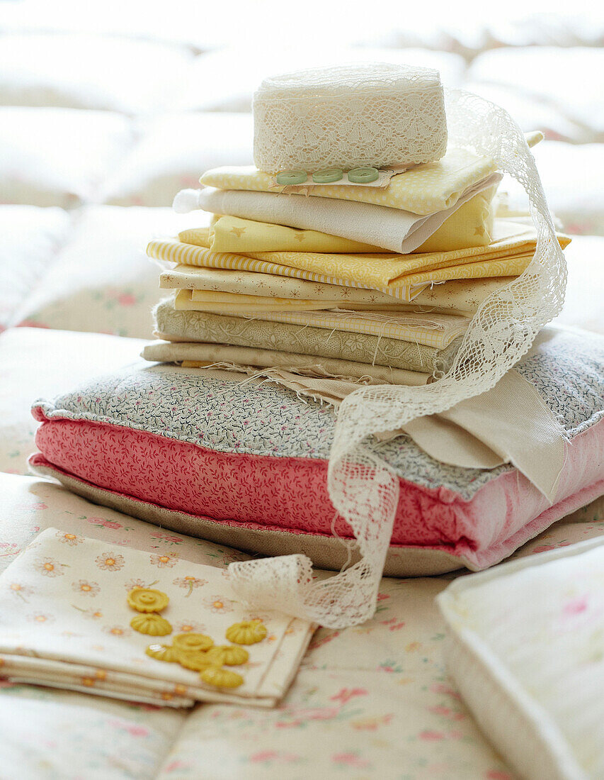 Folded fabrics and buttons with lace on cushion in Devonshire cottage UK