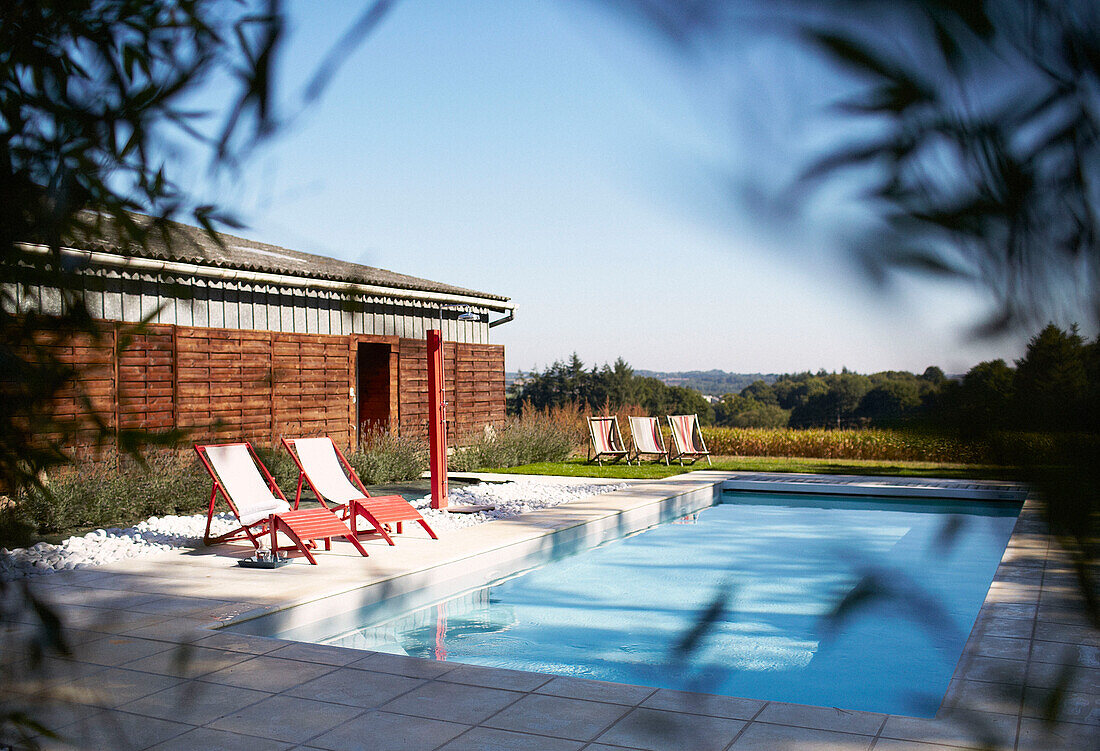 Pair of sunloungers on paved poolside in rural Brittany France