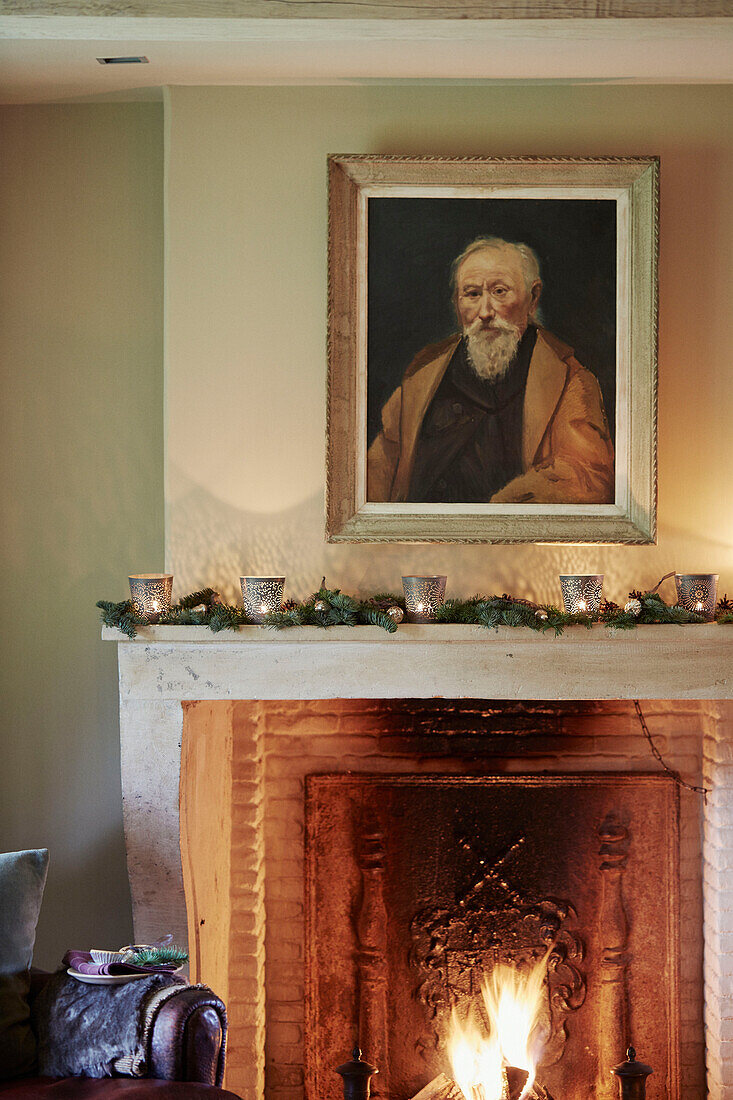 Gerahmtes Porträt über einem brennenden Feuer in einem Haus in Oxfordshire England UK