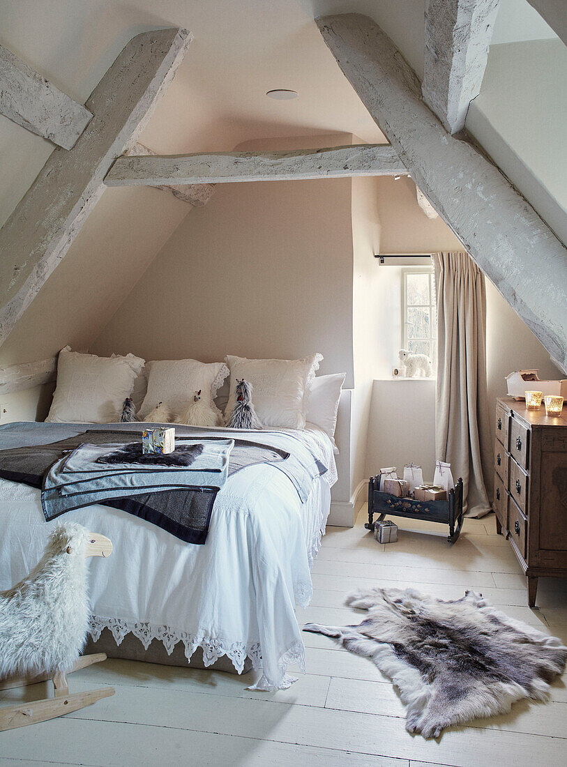 Rocking sheep and double bed in pale pink attic bedroom Oxfordshire England UK