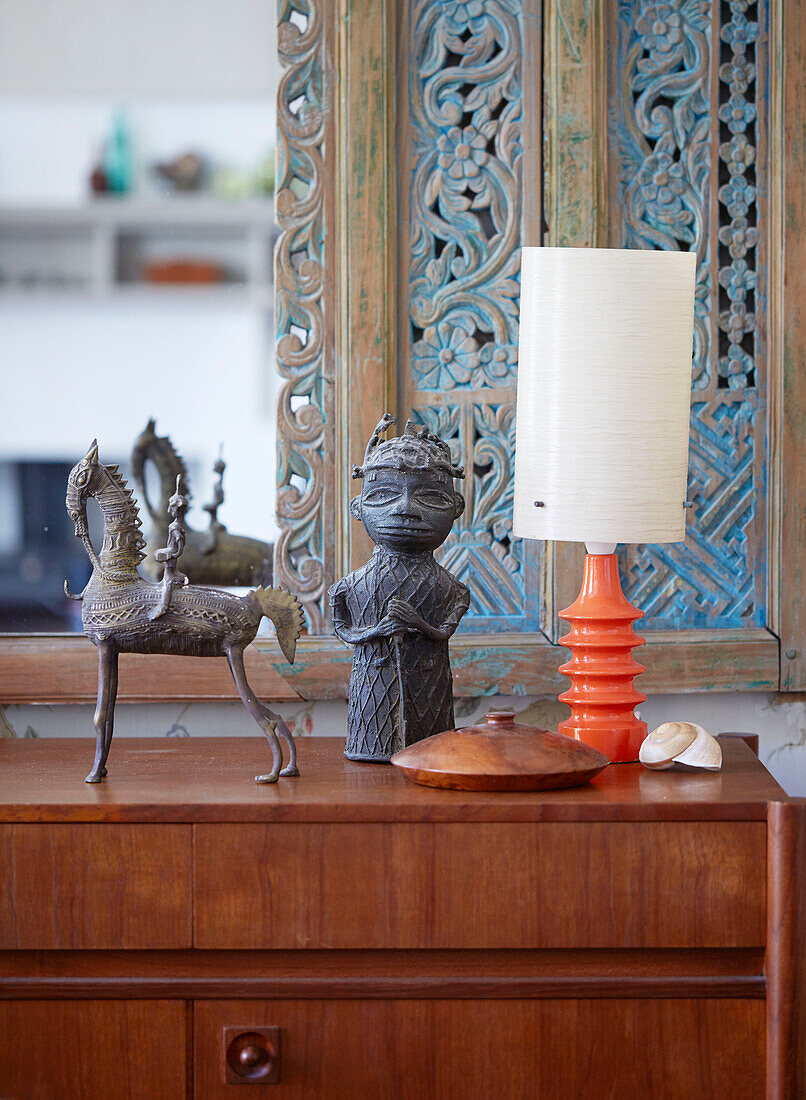 Retro-Lampe und Metallskulpturen auf hölzernem Sideboard in einem Haus in Speldhurst, Kent, England, Vereinigtes Königreich