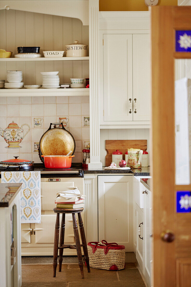 Casserole dish on AGA with books on stool in Hexham kitchen Northumberland UK