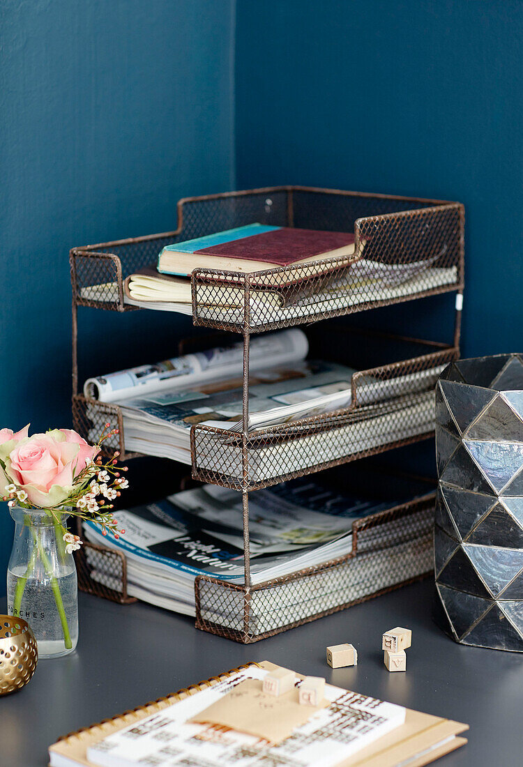 Desk organiser and single stem rose in work studio, UK