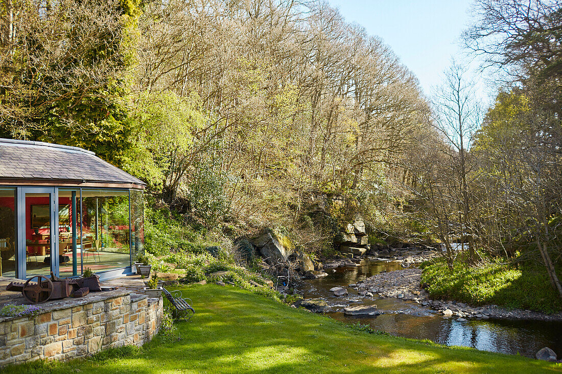 Renovated 18th century Northumbrian mill house on riverbank in woodland, UK