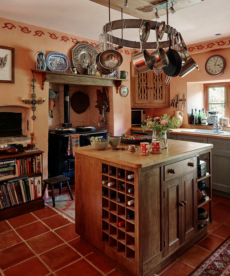Wine rack in kitchen island below pan rack in Herefordshire farmhouse kitchen, UK