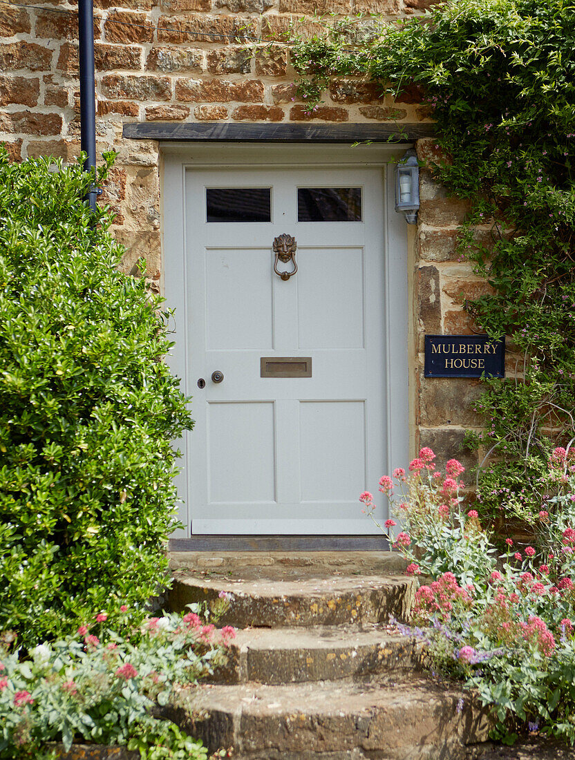 Front doors steps of stone Oxfordshire cottage, England, UK