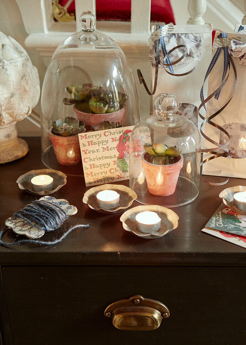 Lit tealights and succulents under belljars on side board at Christmas in Chippenham home, Wiltshire, UK