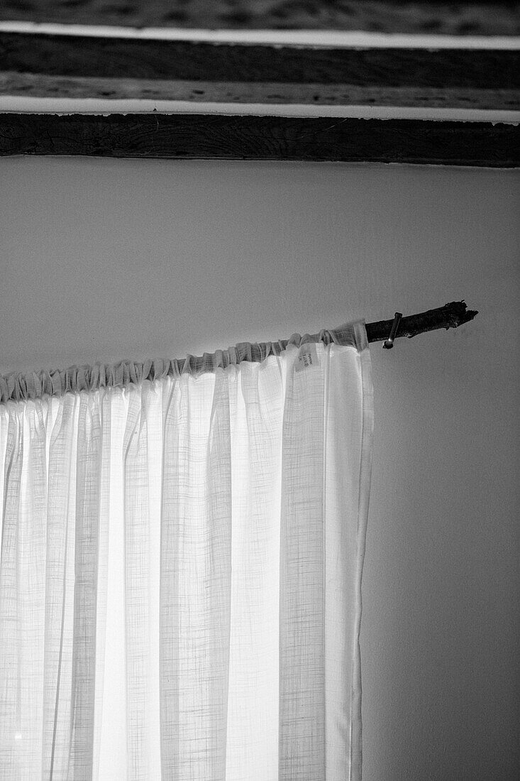 Net curtains under beamed ceiling in Warwickshire farmhouse, England, UK