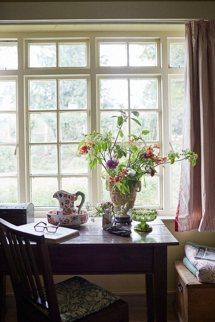 Schnittblumen auf Holztisch am Fenster in einem Cottage in Powys, Wales, UK