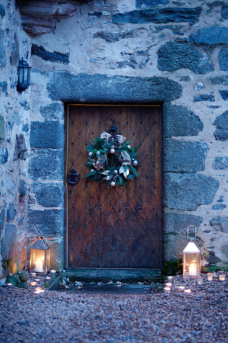 Lit lanterns at old wooden front door of Scottish castle, UK