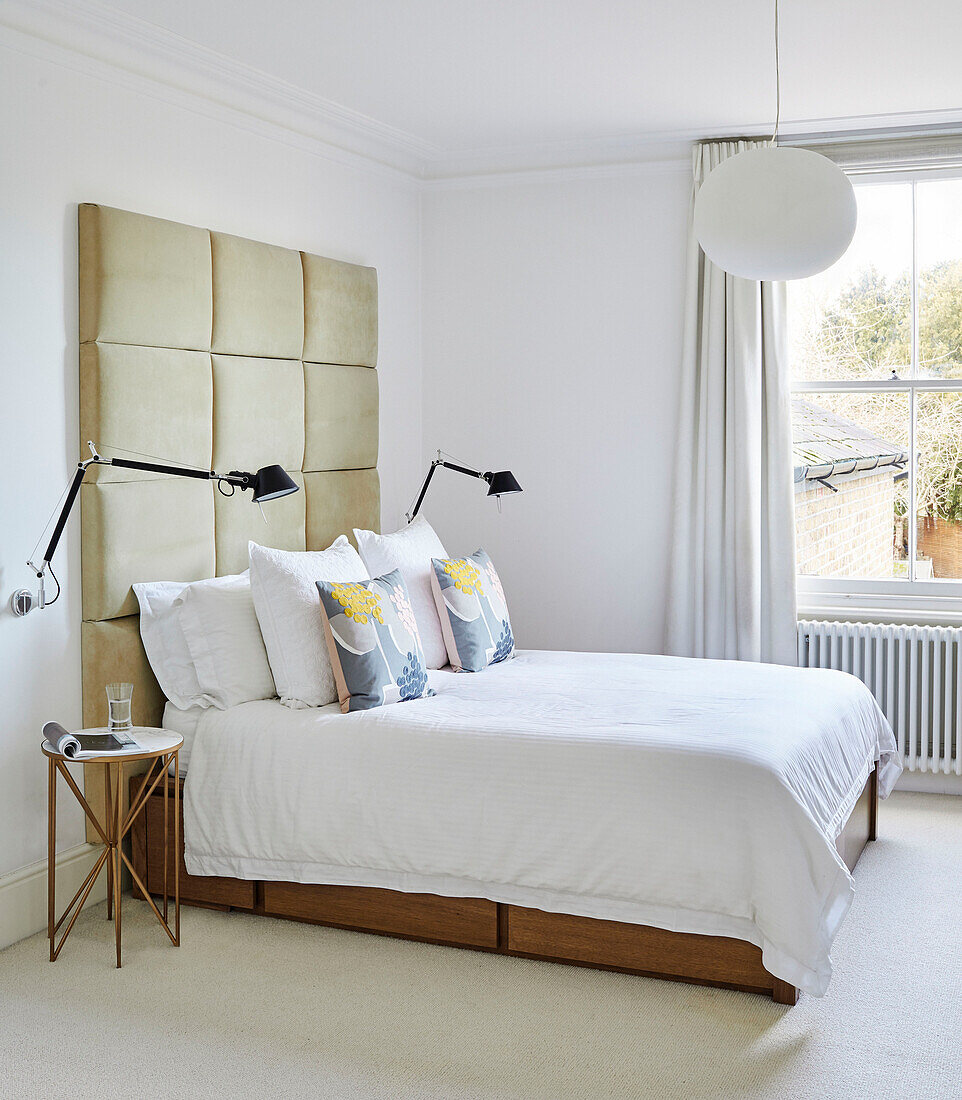 Übergroßes Kopfteil aus Wildleder mit Lampen über einem Doppelbett in einem Haus im Südosten Londons, UK