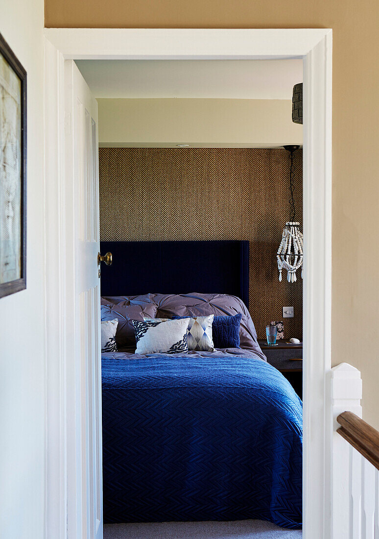 View through doorframed to blue double bed in Northumbrian home, UK