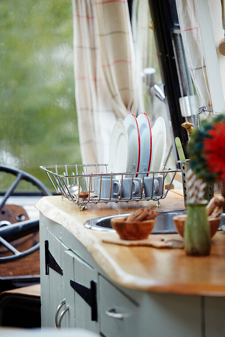 Washing up inside The Majestic bus near Hay-on-Wye, Wales, UK