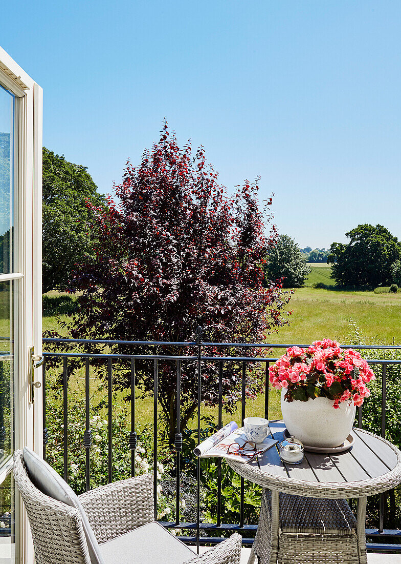 Stuhl und Tisch auf einer Balkonterrasse mit Blick auf die Felder in einem Haus in York, UK