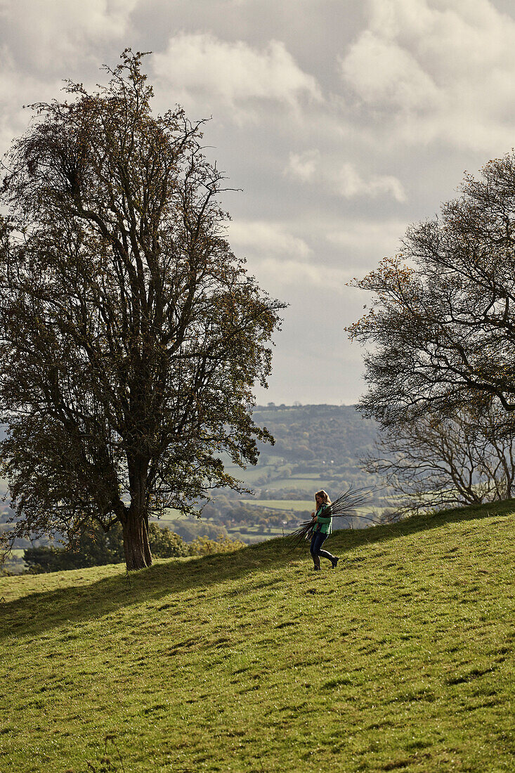 Frau beim Spazierengehen in der Nähe des Offas Dyke-Pfades an der ländlichen Grenze zwischen Radnorshire und Herfordshire, UK