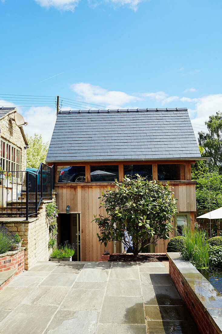 Paved terrace access to wood clad new build in the Cotswolds, UK