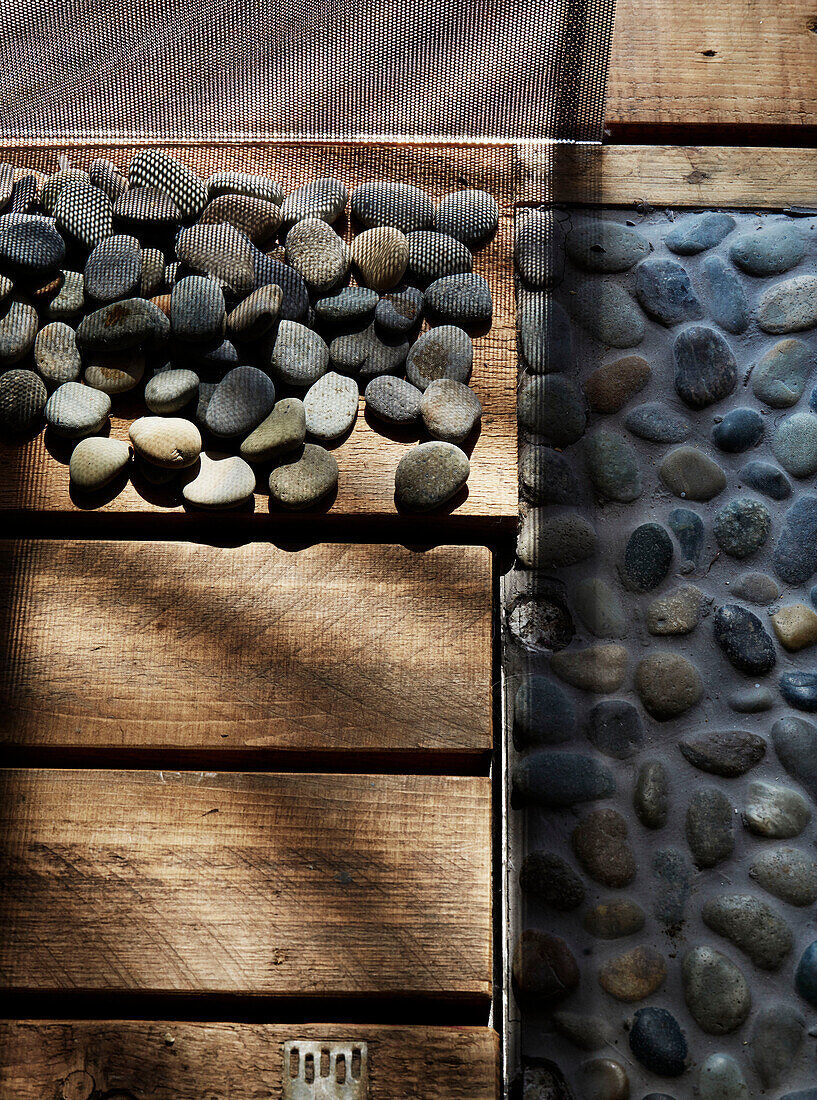 Pebbles and wooden boards in converted shipping container Bedford, UK