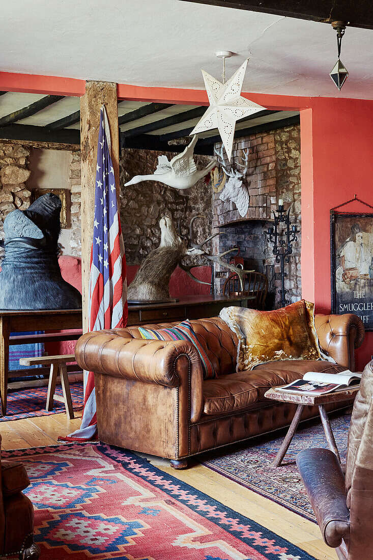 Große Tierköpfe und US-Flagge mit braunem Chesterfield in einem Haus in Devon, UK