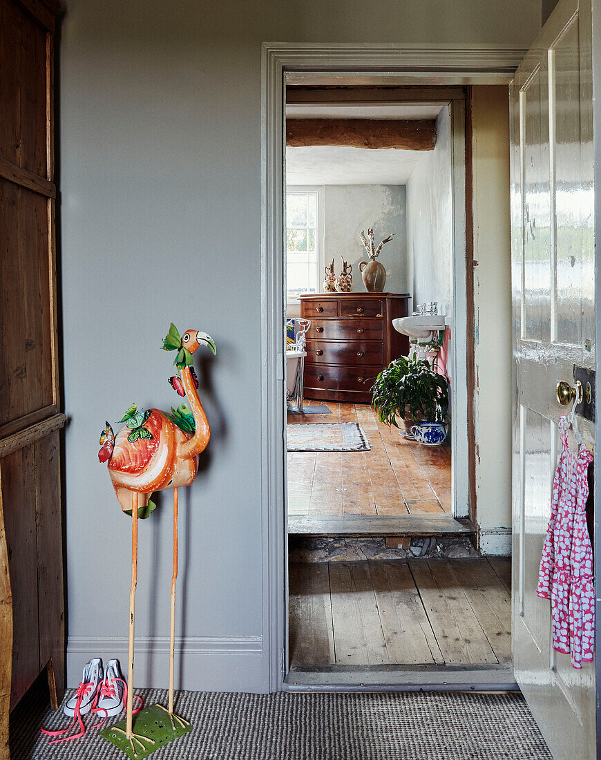 Flamingo statue in open doorway of Devon home, UK