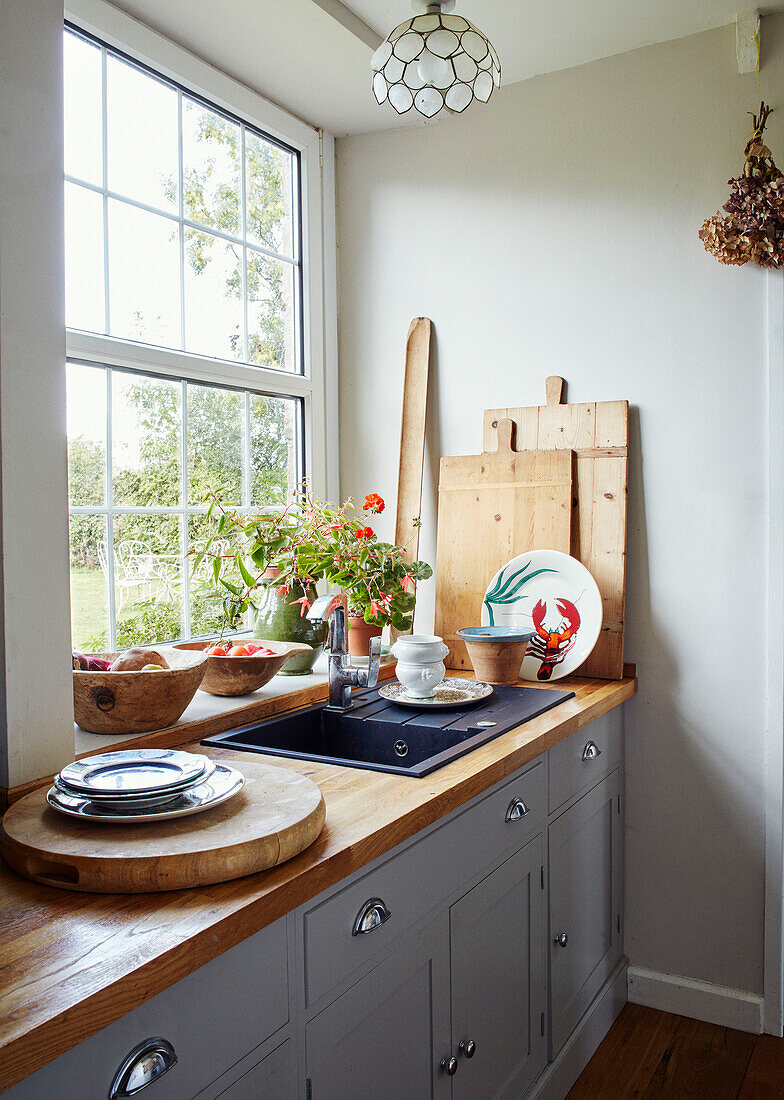 Kitchen sink and chopping boards at window in North Yorkshire farmhouse, UK