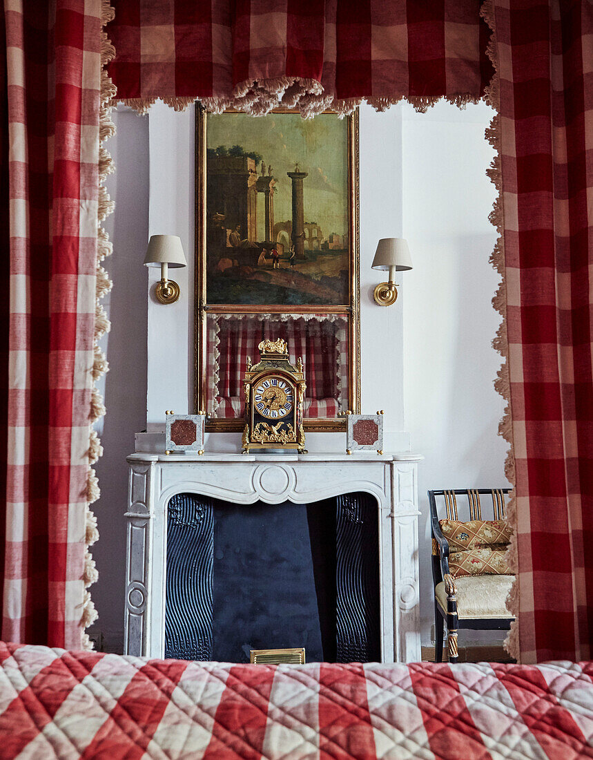 Antike Uhr auf Kamin mit Gingham-Stoff und Himmelbett Foix, Ariege, Frankreich