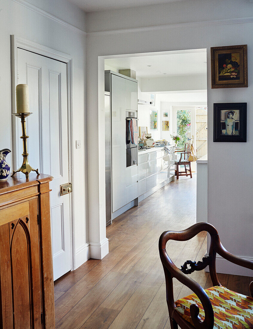 Vintage chair and sideboard with view to kitchen in Northern home, UK