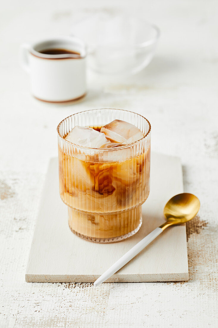 Iced coffee with milk and ice cubes in a glass