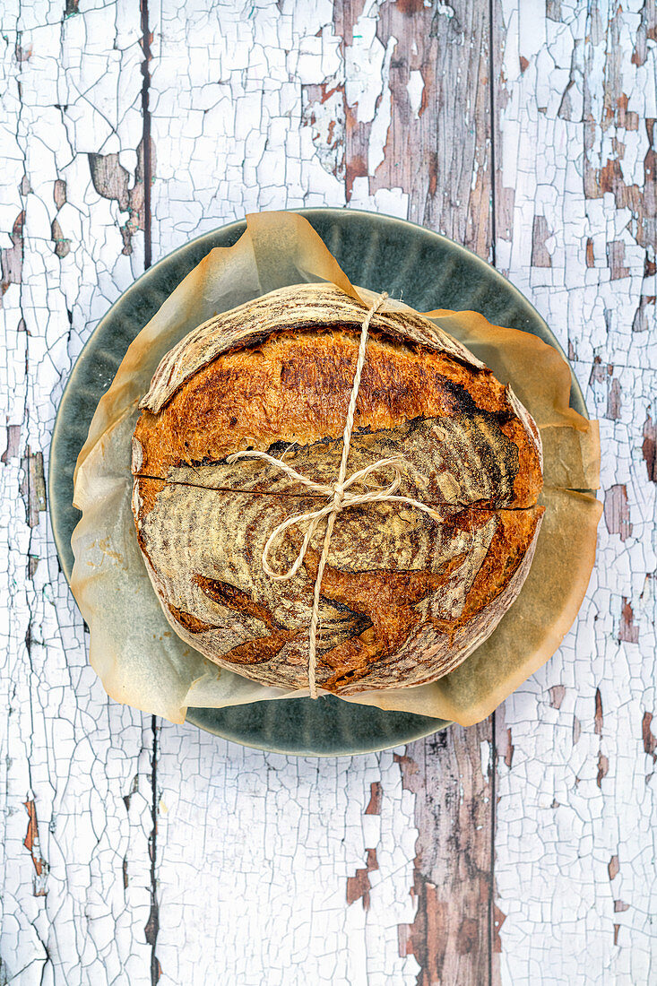 Sourdough loaf tied with twine on a rustic background