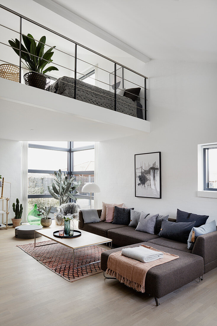 Grey corner sofa in modern, open-plan interior with gallery