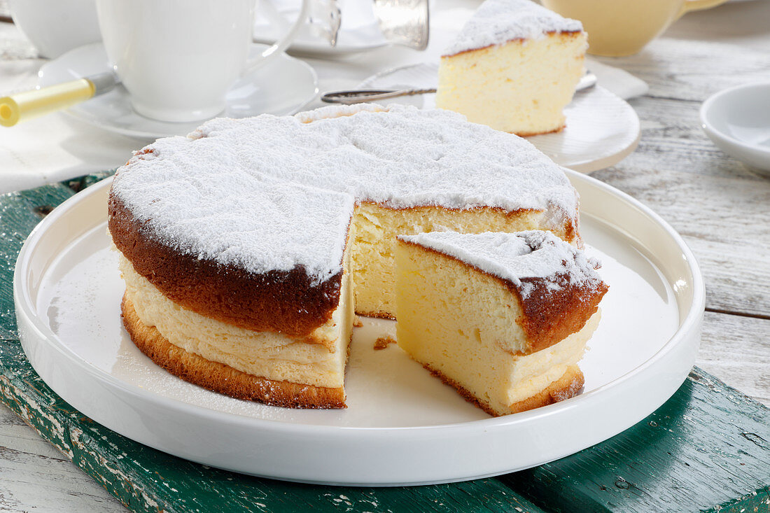 Zitronen-Käsekuchen mit Puderzucker, angeschnitten