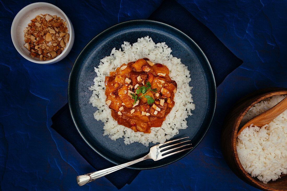 Mango curry with tofu topped with crushed toasted cashews and cilantro on jasmine rice