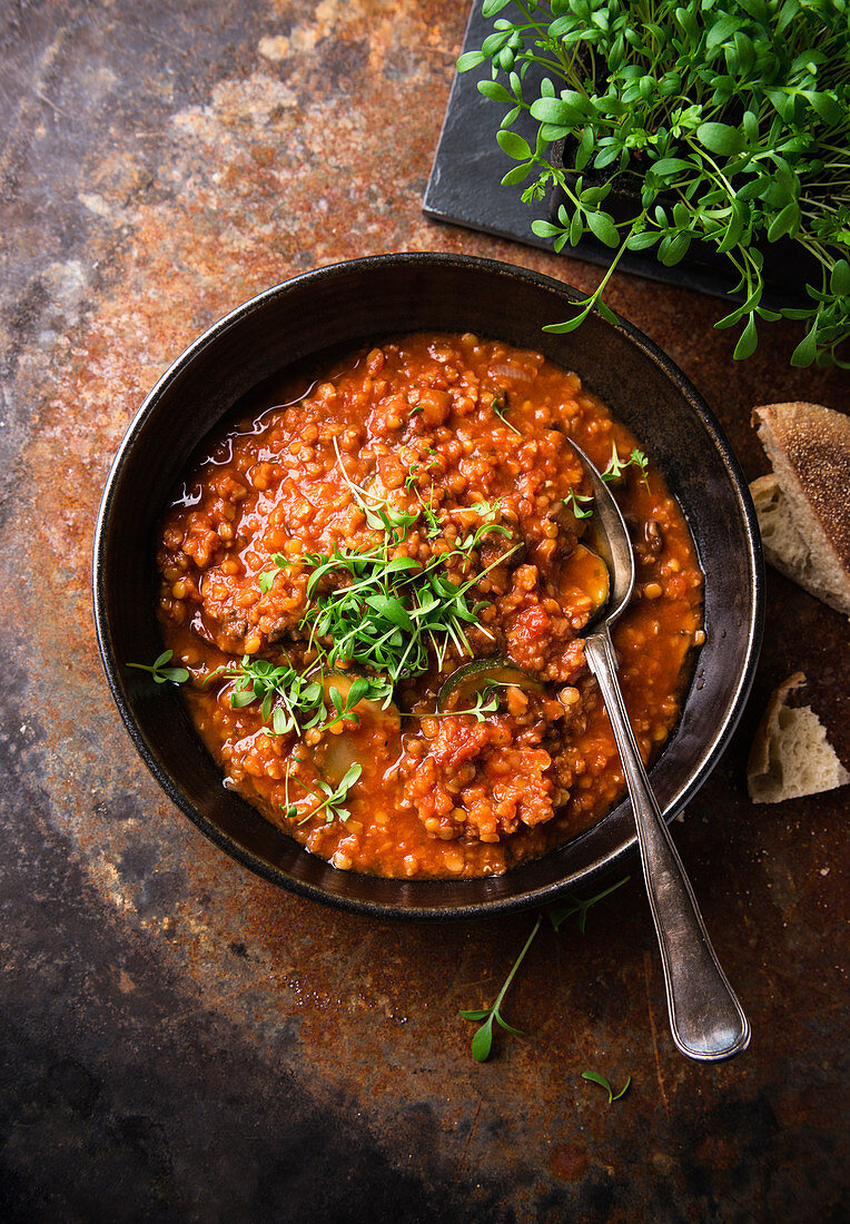 Vegane Linsen-Tomaten-Suppe mit Zucchini und Kresse
