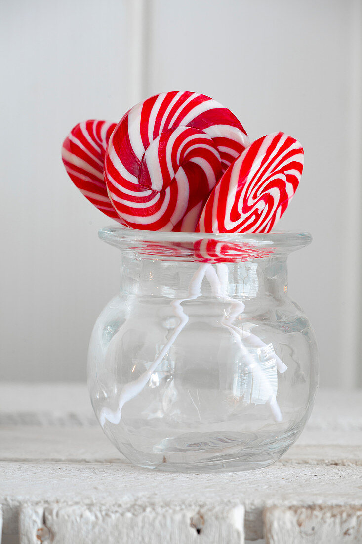 Red and white swirl lollies in a glass jar