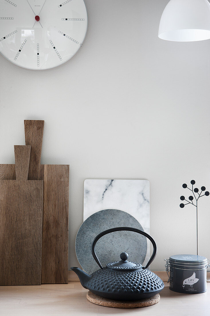 Oriental teapot in front of wood and stone chopping boards