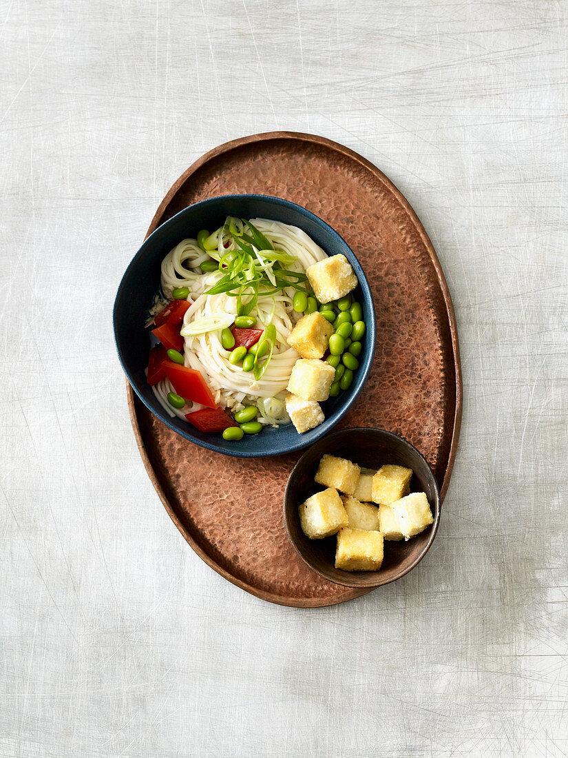 Vegan noodle bowl with fried tofu and edamame beans