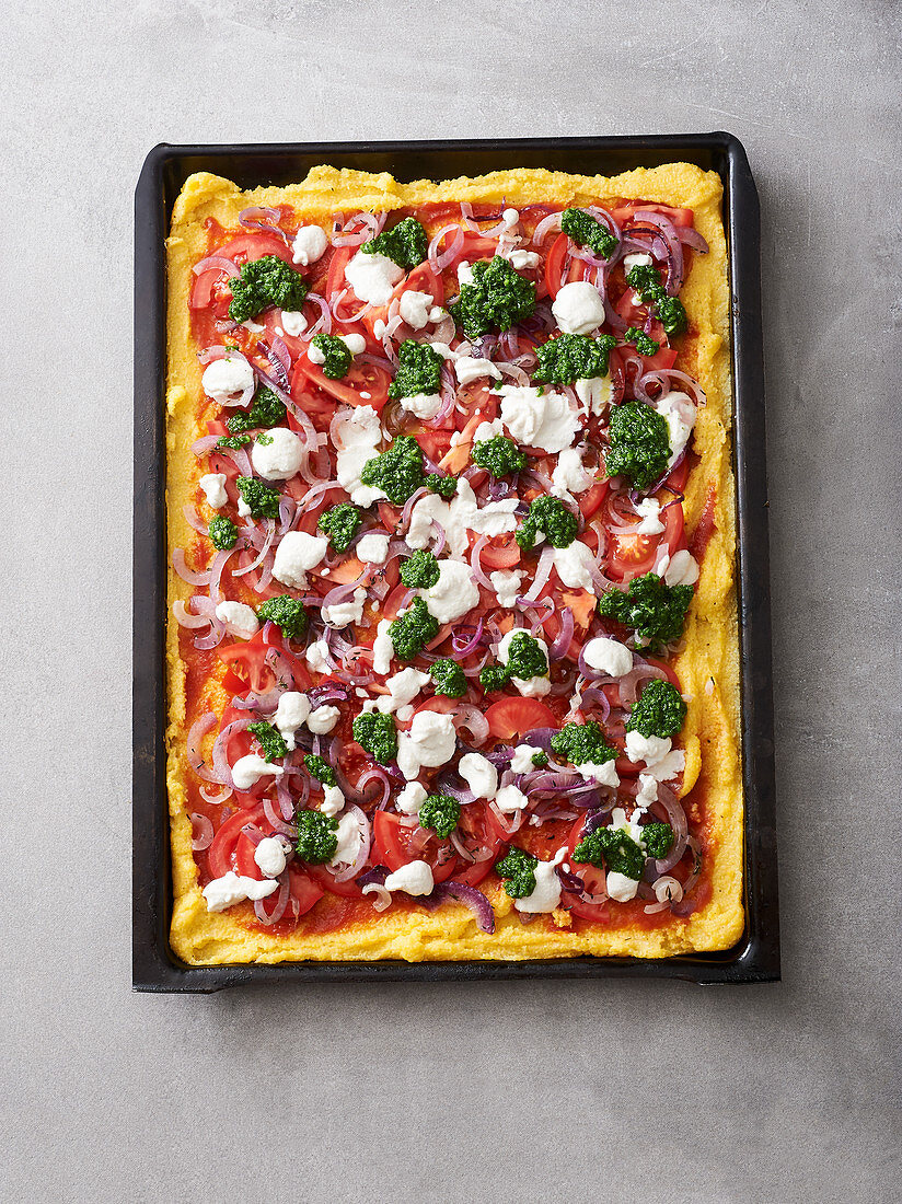 Vegane Polenta-Pizza mit Tomaten, Zwiebeln und Pesto