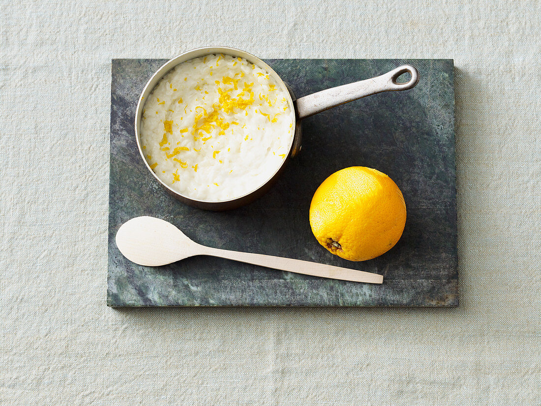 Vegan coconut rice pudding with orange zest in a saucepan