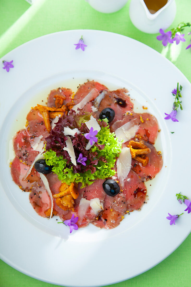 Beef carpaccio with olives, chanterelle mushrooms and parmesan