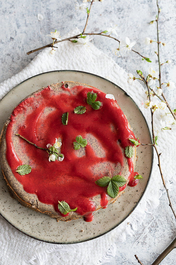 Cheesecake with poppy and strawberry sauce