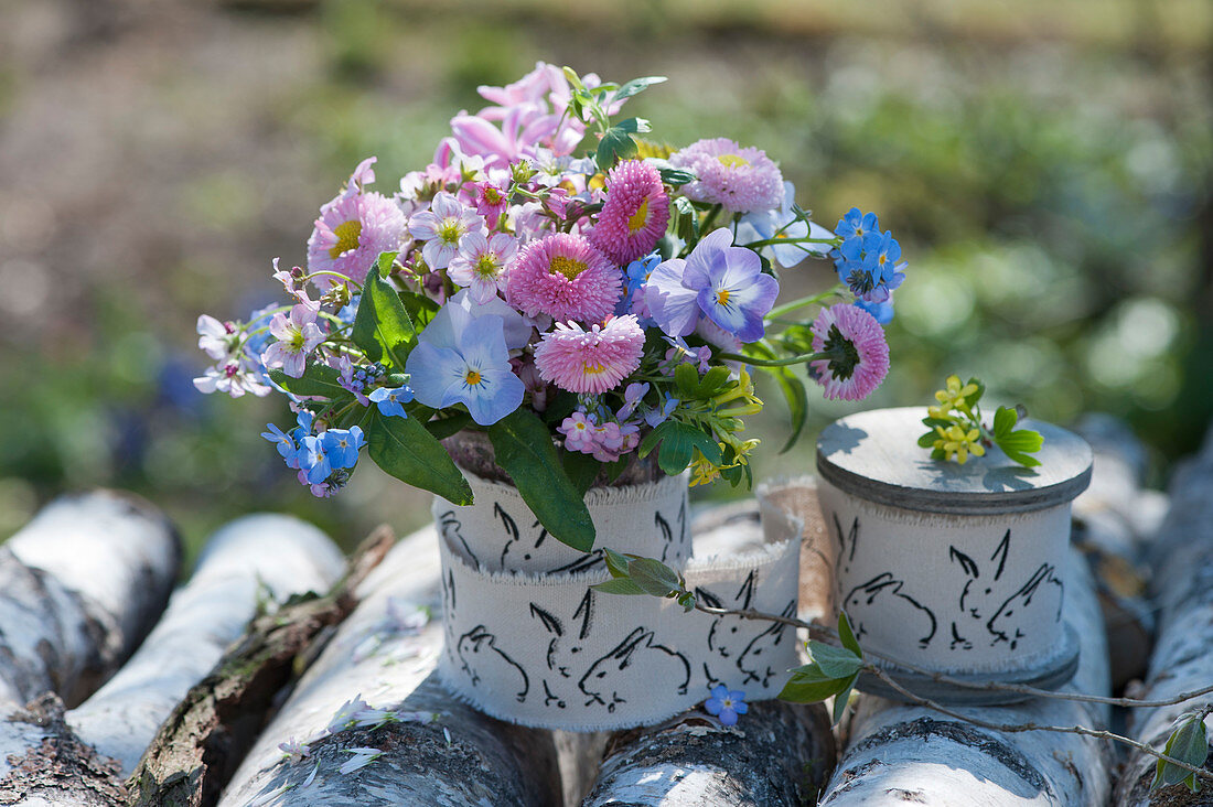 Small bouquet made of a thousand beautiful, horned violets, forget-me-nots, moss saxifrage and gold currant, Easter decoration ribbon