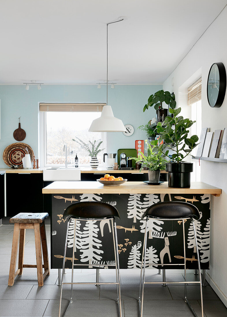 Bar stools at kitchen counter in modern kitchen-dining room