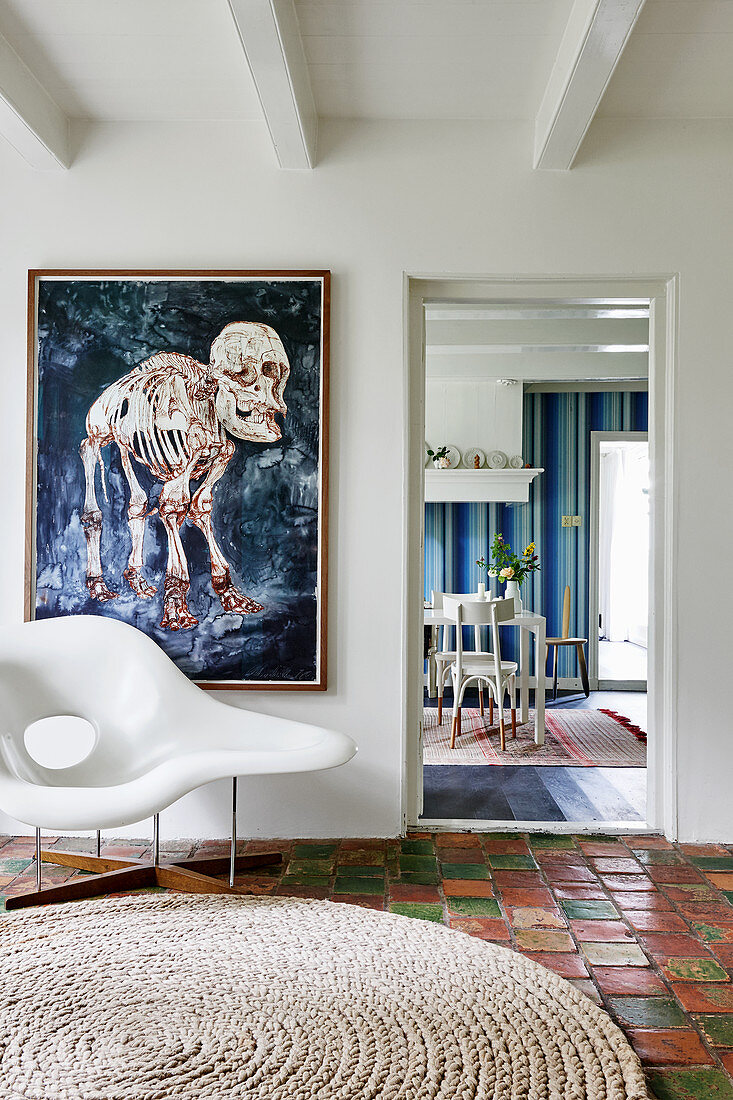 Designerstuhl auf Terrakottafliesen vor moderner Kunst an der Wand