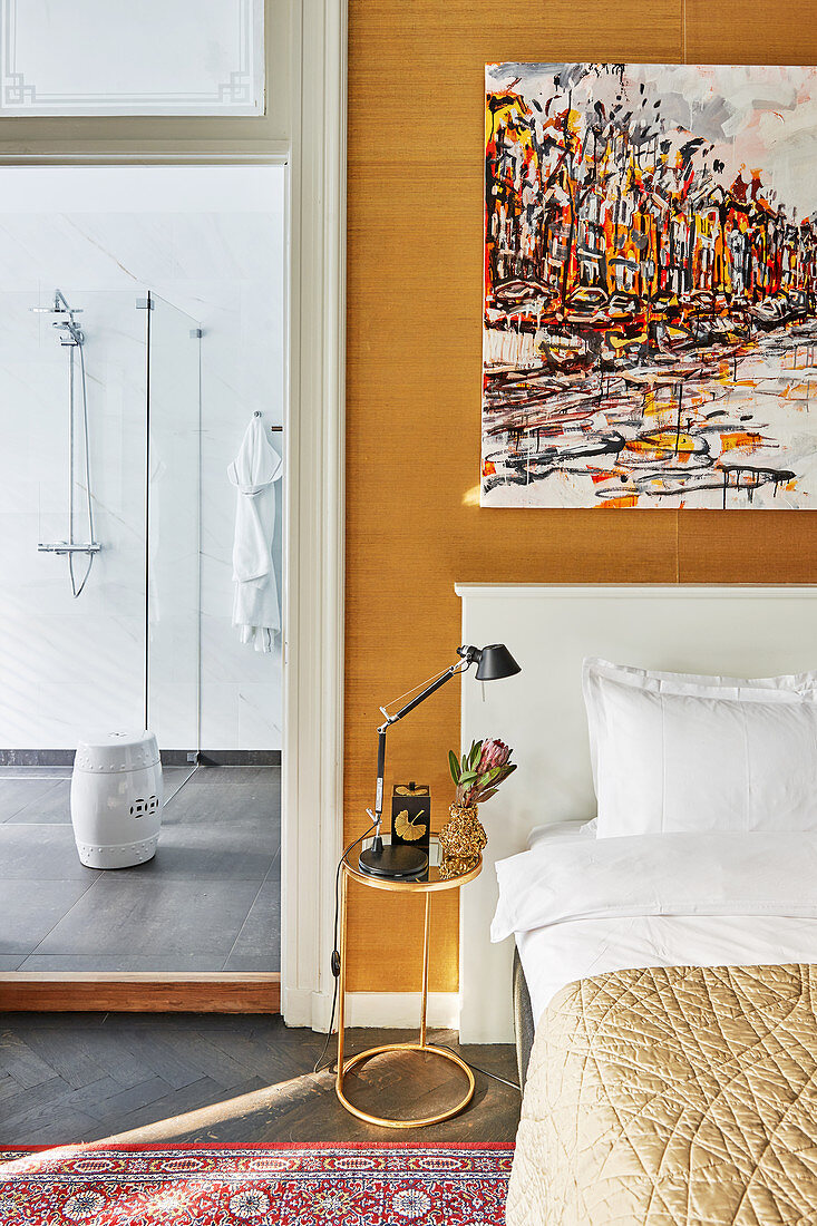 Abstraktes Gemälde überm Bett, Blick ins moderne Bad