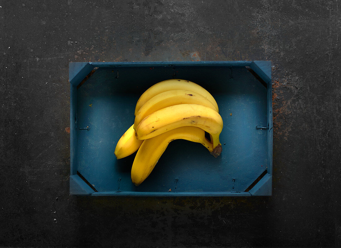 Bananas in a blue wooden crate