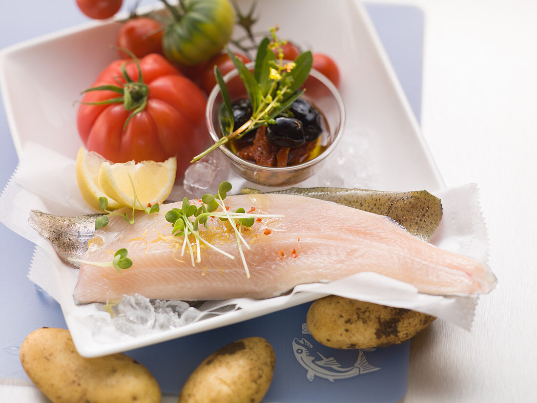 Fresh trout fillets with potatoes, tomatoes and olives