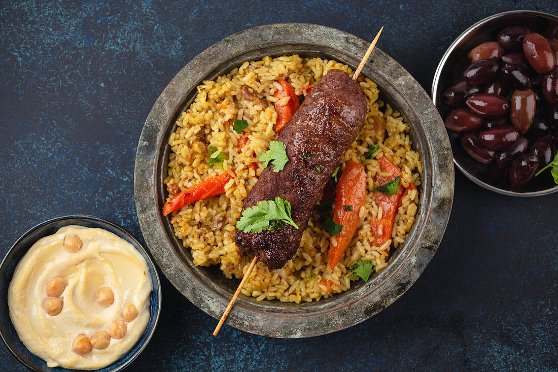 Fleischkebab auf Reis mit Hummus und Oliven (Arabische Küche)
