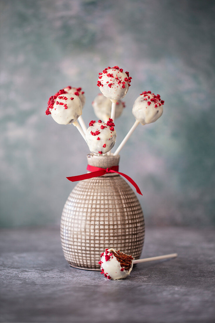 Chocolate vegan cake pops covered with white chocolate and dried raspberries